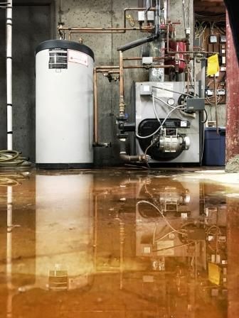 A Vancouver basement flooding with a water boiler and tank in the background