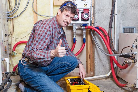 An HVAC specialist performing maintenance on a furnace in North Vancouver